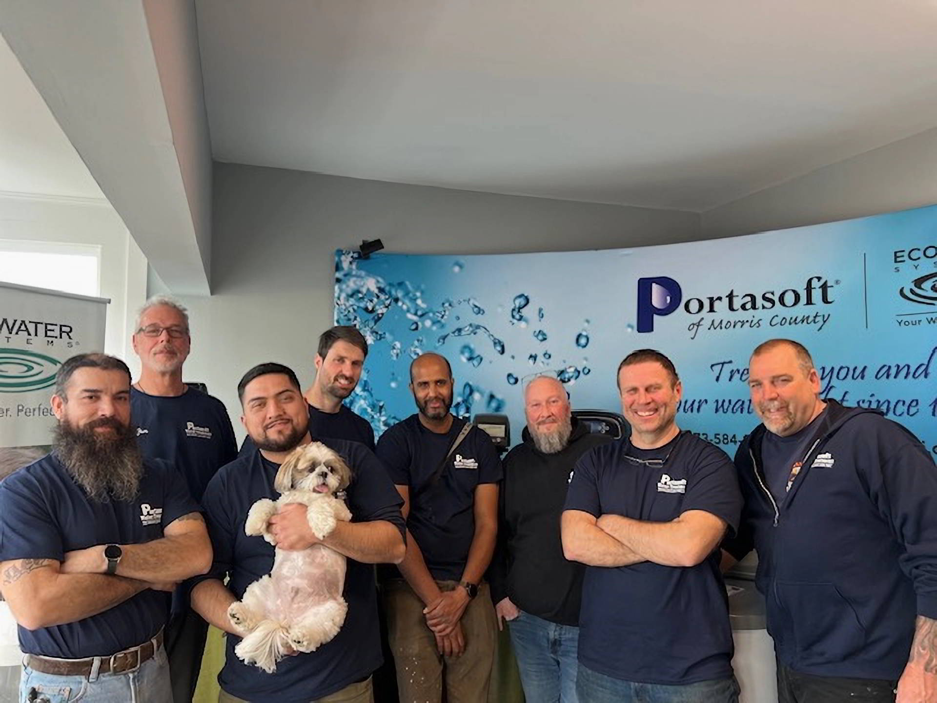 Portasoft team standing in front of banner
