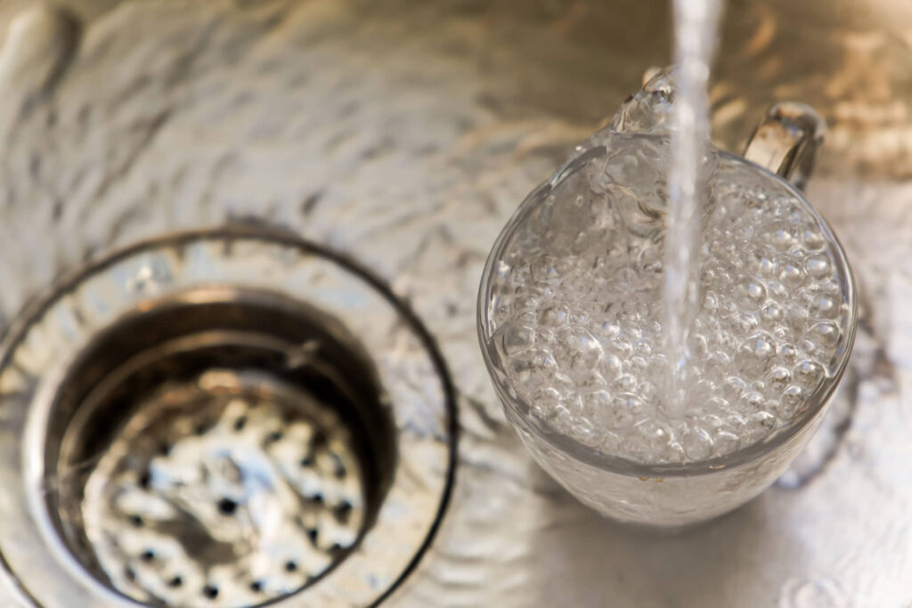 Glass filled with water in a kitchen sink